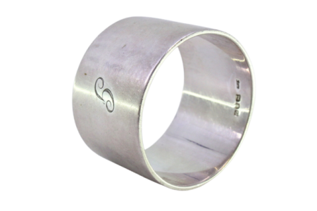 Argola de guardanapo em prata lisa em formato bombeado.